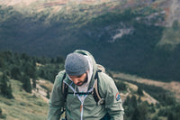 a man in a green jacket hiking