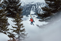 a man in snow carrying skis