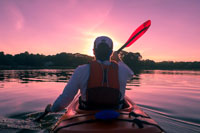 man wearing life vest in kayak