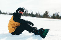 man sitting down with snowboard