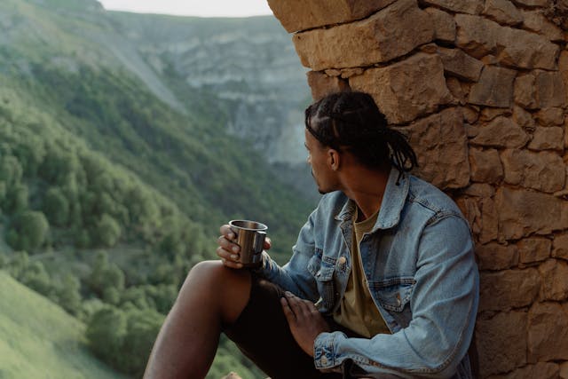 a man sitting near a mountain