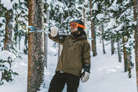 man wearing a winter jacket holding skis