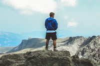 a man wearing shorts on top of a mountain