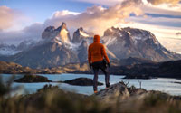 A man wearing a hoodie looking at a mountain