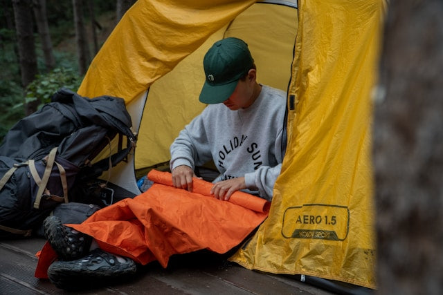 A man rolling up a sleeping pad