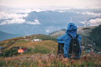 person in jacket sitting with a view of hills