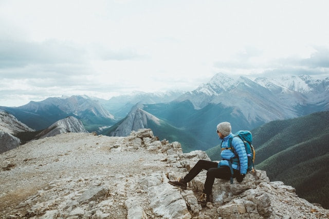 person sitting on a mountaintop