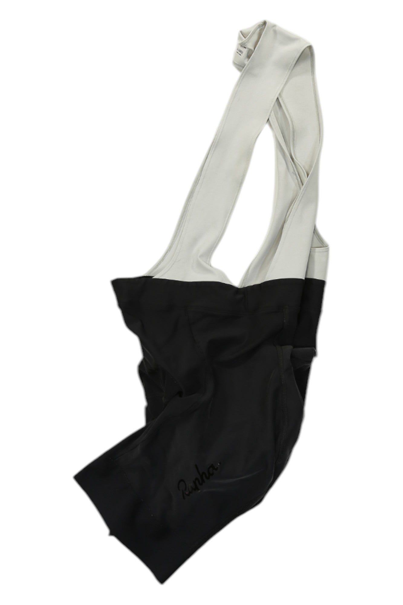 The Rapha Classic Bib Shorts in black with white shoulder straps, designed for cycling performance and featuring "Rapha" on the lower left leg, are laid flat on a white background.