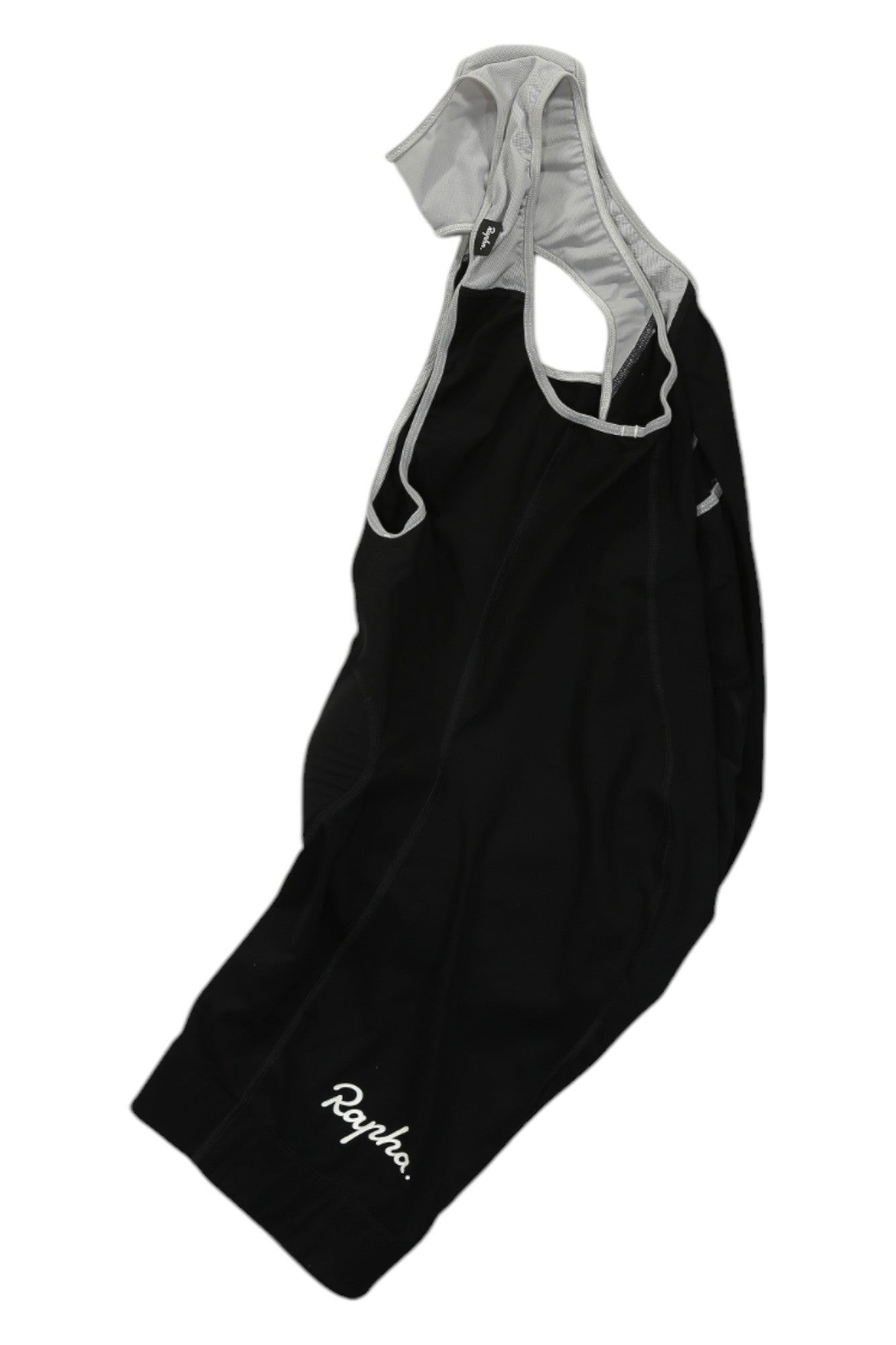 The Rapha Classic Bib Shorts in black feature white trim and shoulder straps, with the Rapha logo printed in white on one leg. Designed for cycling performance, these premium shorts are displayed flat on a white background.