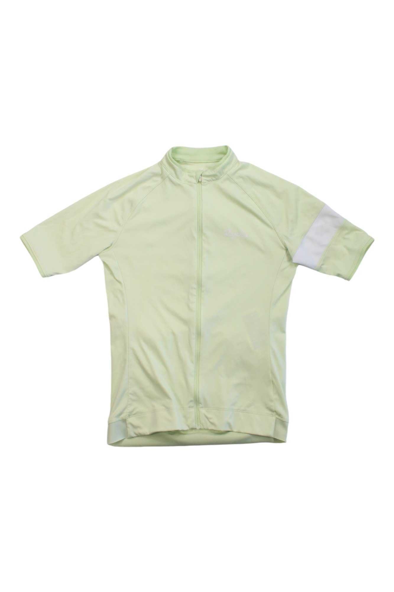 The Rapha Women's Core Jersey is a pale green, breathable cycling jersey with short sleeves, a white band on the right sleeve, and a zipper closure.