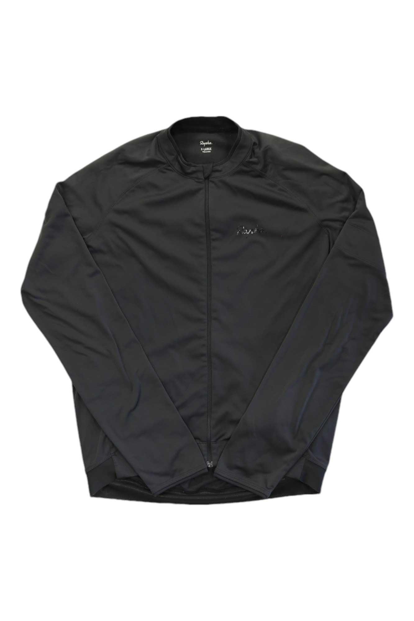 The Rapha Mens Long Sleeve Core Jersey is a black zip-up cycling top with a round neckline and minimalist design, shown laid flat on white. It offers moisture-wicking comfort and features no visible logos or patterns.