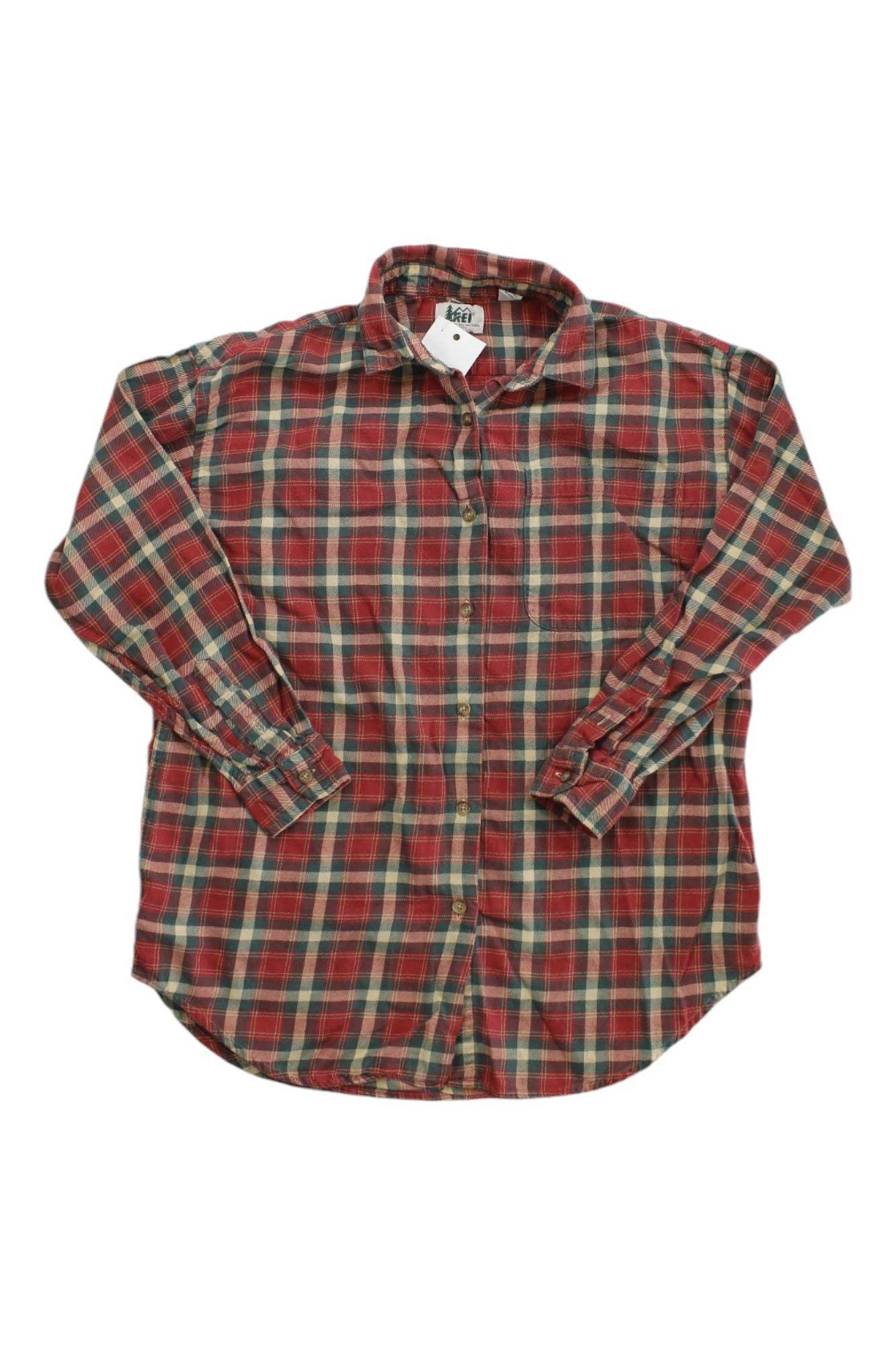 The REI Womens Button Up Flannel Shirt, featuring a red, green, and white plaid pattern and sun-protective long sleeves, is shown flat on a white background.