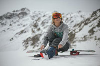 A snowboarder tying their boots