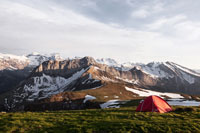 A red tent in front of a mountain range