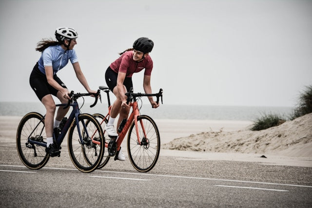 two women cycling on a road