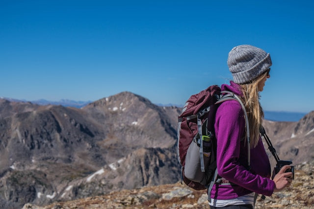 woman hiking in a purple jacket