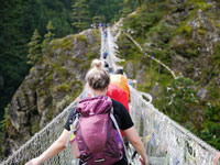  a group of women hiking across a bridge