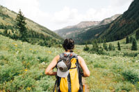 A woman hiking through a mountain pasture