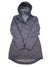 The Women's Tomales Bay Jacket is a long, dark gray waterproof coat with a high collar, front zipper, patterned lining, two side pockets, an extended back hem, and urban style. Displayed flat on a white background.